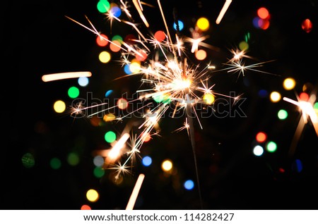 Christmas sparkler and background of colorful bokeh Royalty-Free Stock Photo #114282427