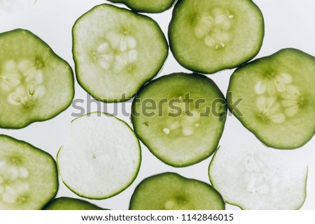 slices of cucumber and zucchini on a white background. cucumbers and zucchini in a cut. background image, beauty salon, facial, face mask. cucumber in the control color, salad, healthy food,vegetables