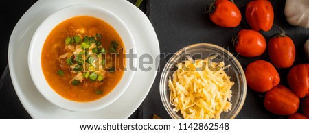 homemade vegetarian tomato cream soup in white bowl on wooden table