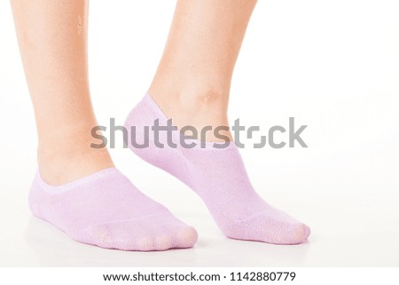 Side view of beautiful human foot dressed in new nice and soft natural cotton fabric blank sock isolated on abstract white background. Wearing and sport clothes concept. Detailed closeup studio shot
