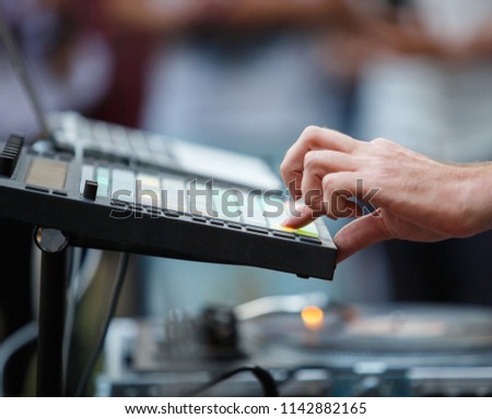 hip hop dj playing beats on drum machine. Disc jockey plays music live on party. Professional disk jokey beat machine on concert stage. Producer play beat on midi pad controller 