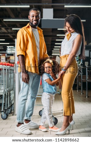 young african american parents with little daughter in grocery store