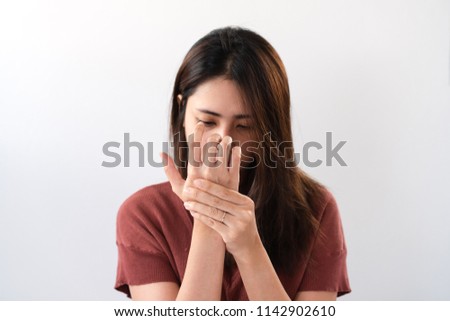 Young asian woman suffering from pain in palms. Female massaging her painful hand from symptoms of Peripheral Neuropathy. Pain and numbness in fingertips and palms. Health care and physical concept.
