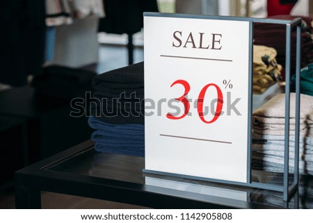 Sign in a clothing store with discount inscription SALE 30 % percent. Plate discount (sale)