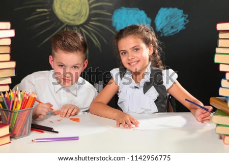 Boy and girl at school,students with books at the Desk. New academic year. Primary education. Photos in the room. School style. Children. Disciples.
