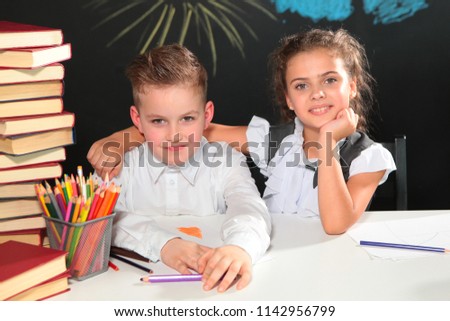 Boy and girl at school,students with books at the Desk. New academic year. Primary education. Photos in the room. School style. Children. Disciples.