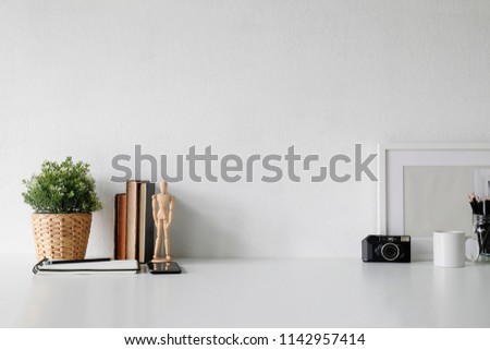 Stylish workspace with poster, book and gadget. Workplace desk and copy space.