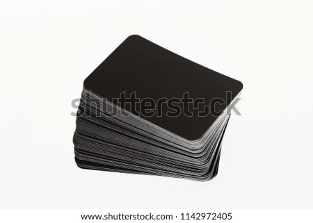 Stacked black blank business cards on white background, mock up for branding. Round shaped cardboard tags