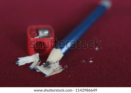 Blue pencil and red pencil sharpener On a red background
