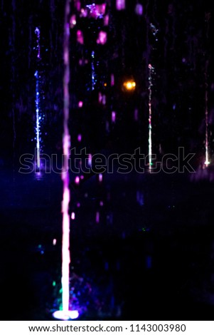 Volcano - Colorful fountain in the night city landscape. Dark background.