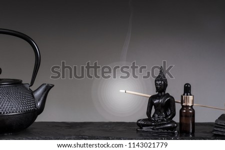 Zen still life. Buddha statue on black simple background