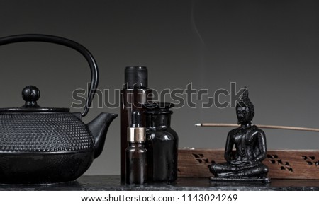 Aromatherapy oils. Massage and spa Concept. Buddha Statue ond black simple background