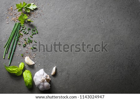 Top Down View On Kitchen Ingredients Like Garlic, Basil, Spices And Herbs On Slate Stone, With Free Space In The Middle And Right Side Royalty-Free Stock Photo #1143024947