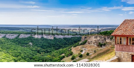 Panoramic picture. The valley of Josaphat. On the right is the rocky medieval cave town of Chufut-Kale. Next, the Assumption Rock. In the distance the city of Bakhchisaray. Republic of Crimea.