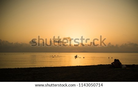 Sunset on the beach of La Manga in the Mar Menor; people enjoying the bathroom