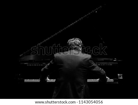 pianist from his back playing in the dark