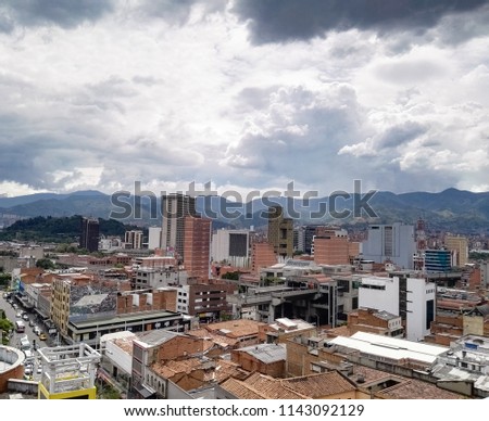 Panoramic view of the city center of Medellin (downtown), Colombia, with commercial buildings, elevated metro station (San Antonio), streets crowded with cars and background of the typical mountains