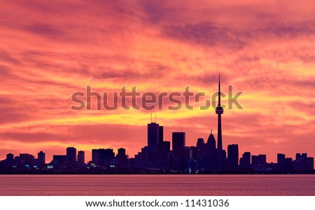 Toronto's downtown core set against glowing orange sky moments before sunrise