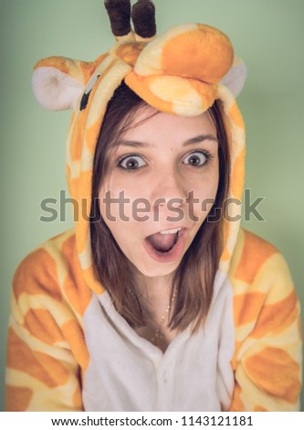 girl in a bright children's pajamas in the form of a kangaroo. emotional portrait of a student. costume presentation of children's animator. Slippers in the form of cat's paws.