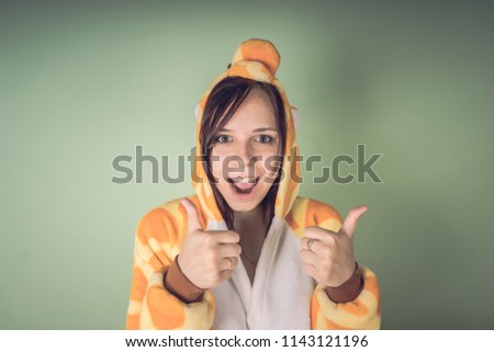 girl in a bright children's pajamas in the form of a kangaroo. emotional portrait of a student. costume presentation of children's animator. Slippers in the form of cat's paws.