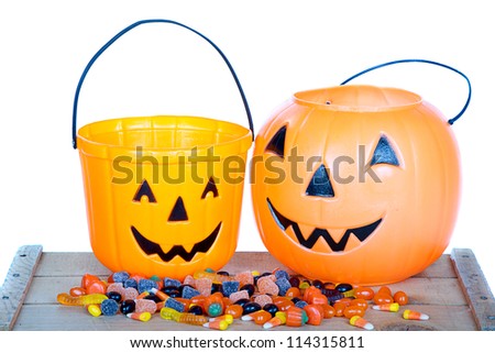 Halloween candy and pumpkin bucket on wooden plank, Isolated white background