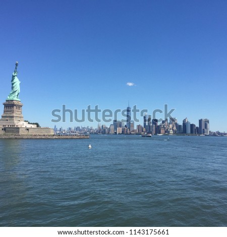 The statue of Liberty with World Trade Center background and the city skyline, Landmarks of New York City. The Statue of Liberty is a colossal neoclassical sculpture on Liberty Island.