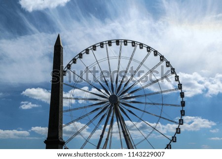 A Picture of a silhouette of the ferris Wheel and obelisk at Place de la Concorde at Paris. 
