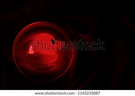 Transparency​ red​ duck doll​ in​ plastic​ cup​ on​ black​ ground​