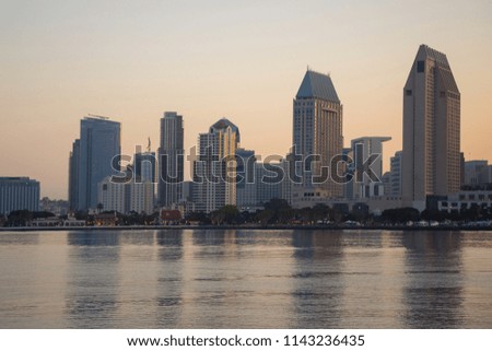 View of the San Diego doutown from the Coronado Island in the early morning at sunrise. Skyscrapers are reflected in the water. Toned photo.