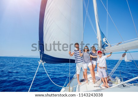 Happy family with adorable daughter and son resting on a big yacht Royalty-Free Stock Photo #1143243038