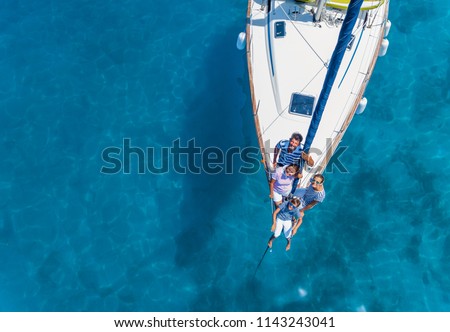 Aeiral view of Happy family with adorable daughter and son resting on a big yacht. Drone photography Royalty-Free Stock Photo #1143243041