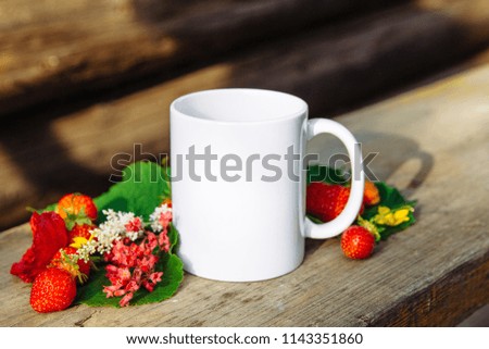 white mug on a wooden background and berries Royalty-Free Stock Photo #1143351860