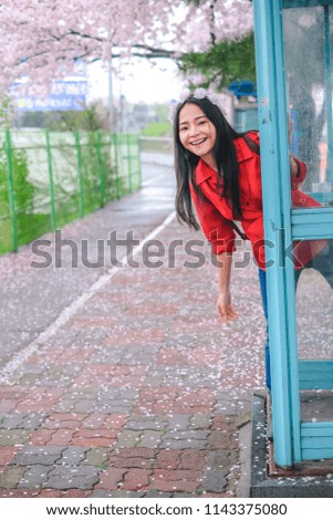 Young pretty girl in callbox at Jinhae cherry blossom festival in Jinhae city of South Korea on April 2018.
