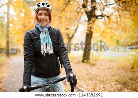 Image of smiling woman in helmet on bicycle