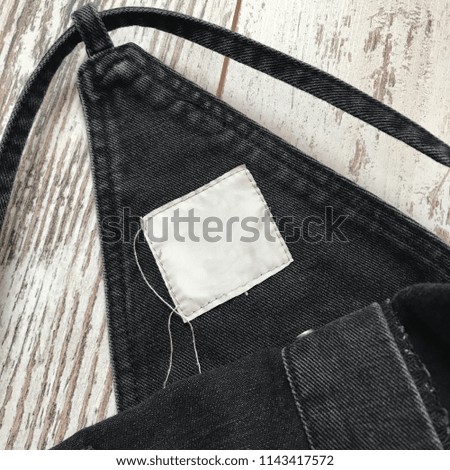Details of denim overalls on a wooden background