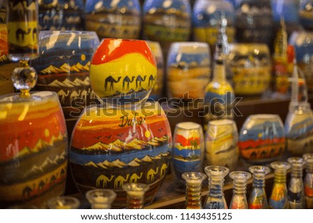 Sand bottle souvenirs at the Madinat Jumeirah Souk, Dubai, UAE. Decorative glass bottles with colored sand inside making shapes of desert and camels
