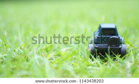 Back of blue mini toy car on green grass
