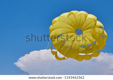 dome of the yellow parachute on the blue sky.