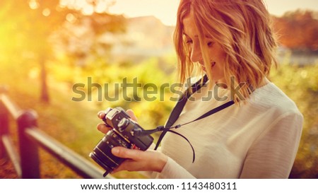 Photographer girl with mirrorless camera take photo in autumn