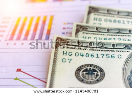 Banknote and coins depicted on economic graphs dollar currency, financial investment concepts that affect the global economy and people's spending, and saving money for future use for indissolubility.