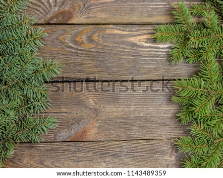 Christmas close-up of Christmas tree branches on vintage wooden background. Top view of a Christmas workplace. New Year frame or Xmas Mockup. Royalty-Free Stock Photo #1143489359