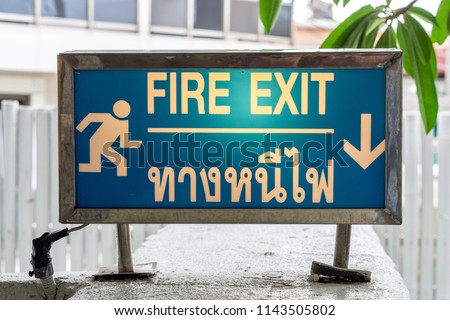 Fire exit sign that have a content in Thai and English. This sign is for emergency case.