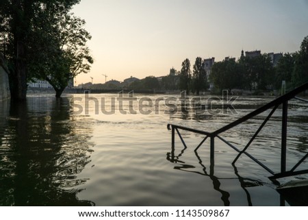 Cityscape view of the swelling of Seine river, with skyline & under water stairs in sunset, with the reflection on the water, during the flood in spring in Paris, Ile Saint-Louis, France, Europe.