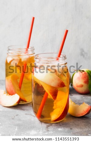 Peach nectarine cold ice tea lemonad different ingredients two glasses jar on gray background.