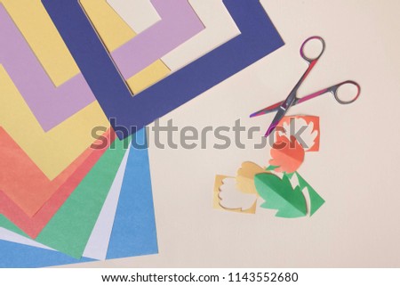 Color paper on the table. Decorative paper elements cut with scissors.