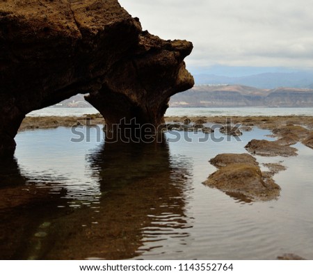Rock with hole during low tide, coast of Las Palmas de Gran Canaria, El Confital, Canary Islands