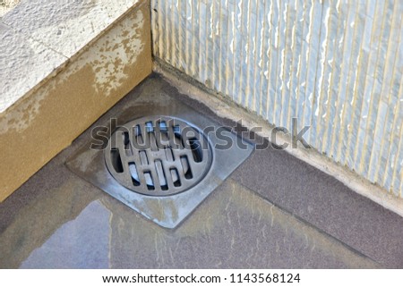 Shower drain box grate on a shower base. Sand and dirt on the floor. Cleaning required Royalty-Free Stock Photo #1143568124