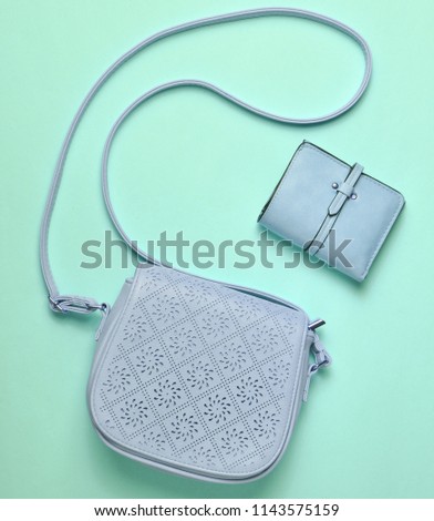 Women's leather bag and purse on a blue pastel background, women's accessories, top view, minimalism
