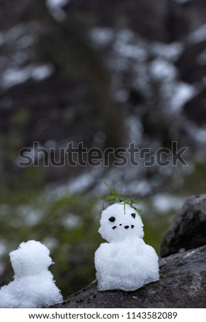 
little snowmen on a rock