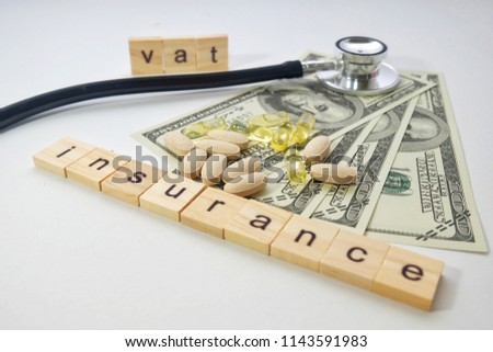 A bokeh picture of fake note, medicines,stethoscope and word tiles create the word insurance with VAT. Insurance is part of the people financial planning. 